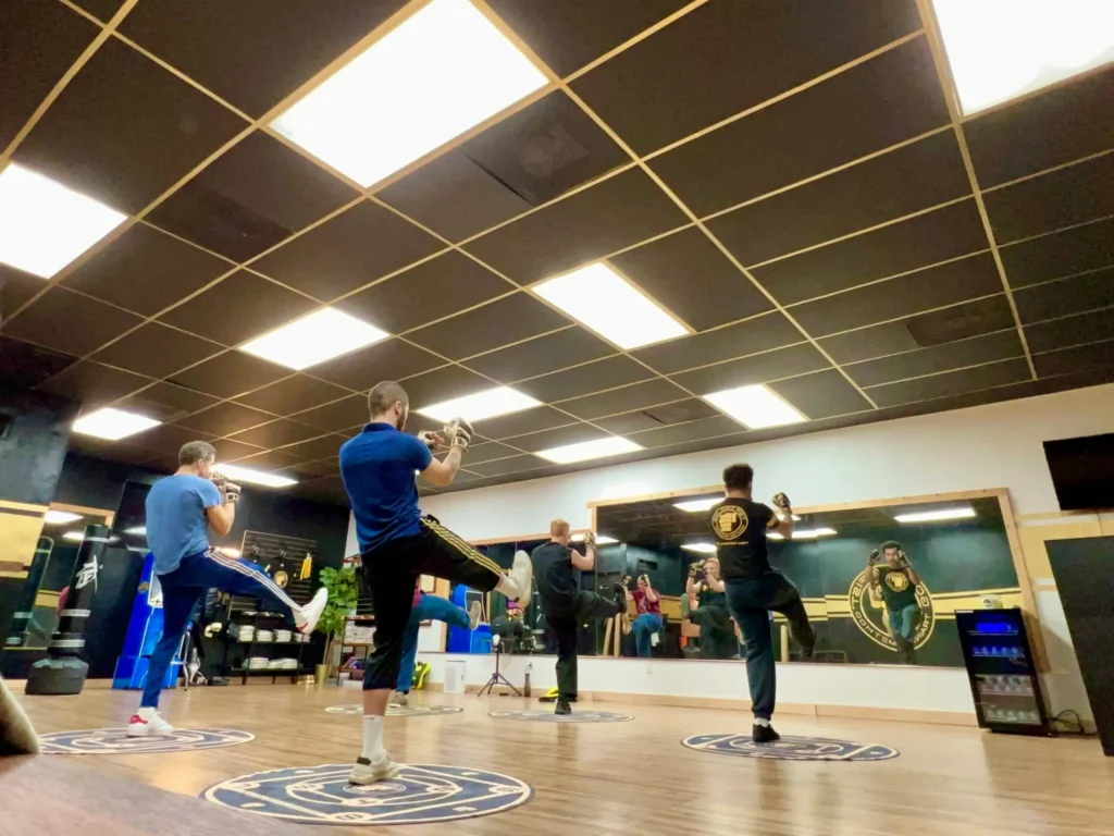 Adults practice controlled front kicks on Golden Fist Training Circles during a GFTM class.